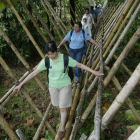 Journalist walking across a bamboo bridge