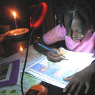 A girl uses a Barefoot Power solar-powered lamp