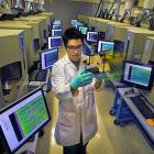 A researcher among a bank of DNA analysis machines A researcher among a bank of DNA analysis machines