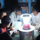 Des enfants assis autour d'une lampe solaire