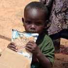 Child in Somalia receiving food distributed by FMSC and GAiN