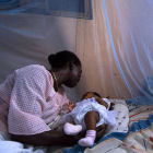 Mother with child under bednet