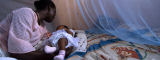 Mother and child under malaria bednet, Ghana by Flickr/World Bank Photo Collection