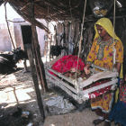 Mother with baby in outhouse shared with cattle, Pakistan