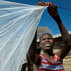 A woman airs out a bednet