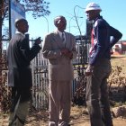 Three african men standing outside in suits