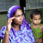 A Bangladeshi mother and child outside a flooded home