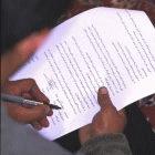Young man signing consent form to participate in clinical trial in Iran.