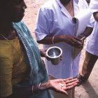 A woman takes medication as part of an attempt to control the spread of filariasis