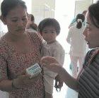 A health worker explains how to give a child iron supplements