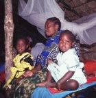 A mother and her daughters under a bednet in Tanzania