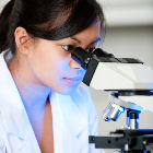 Researcher using microscope