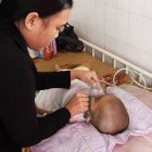 A mother cares for a child with pneumonia in Indonesia