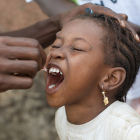 Girl receiving oral polio vaccine