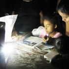 Children using portable light to read