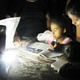 Children using portable light to read