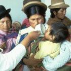 A doctor administers oral rehydration solution to a Peruvian child