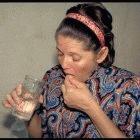 A patient takes her daily treatment at a TB clinic