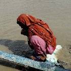 Pakistani woman drinking dirty flood water